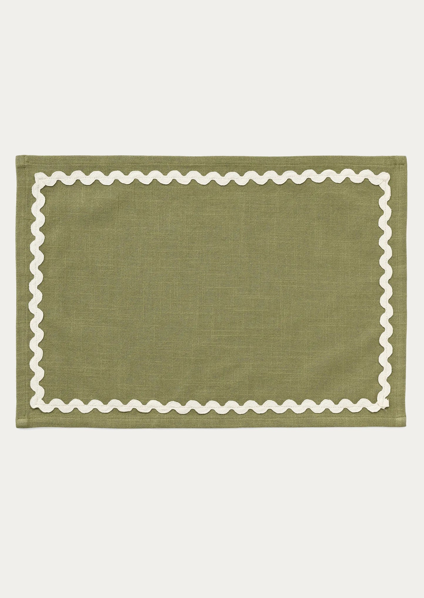 A moss green placemat with white ricrac trim border.