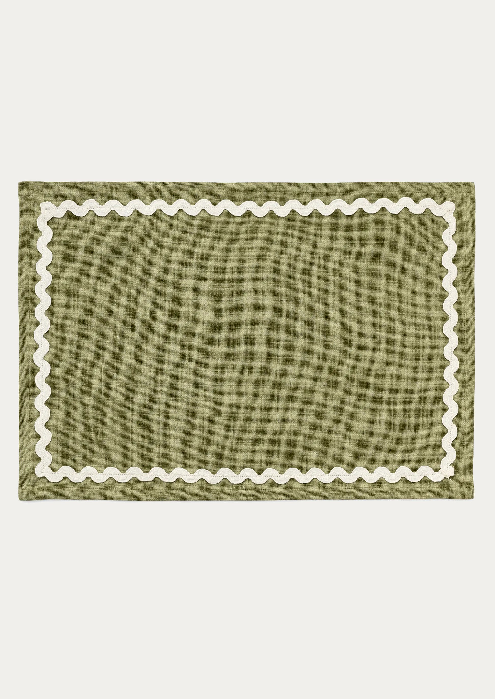 A moss green placemat with white ricrac trim border.