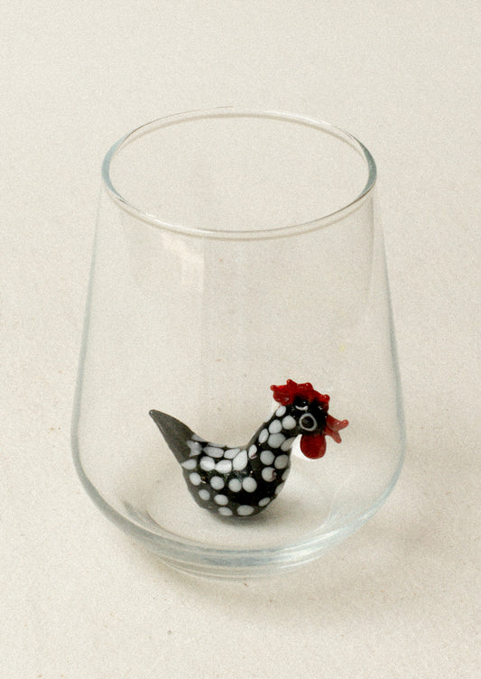 A glass with lampwork rooster detail at bottom of inside glass.