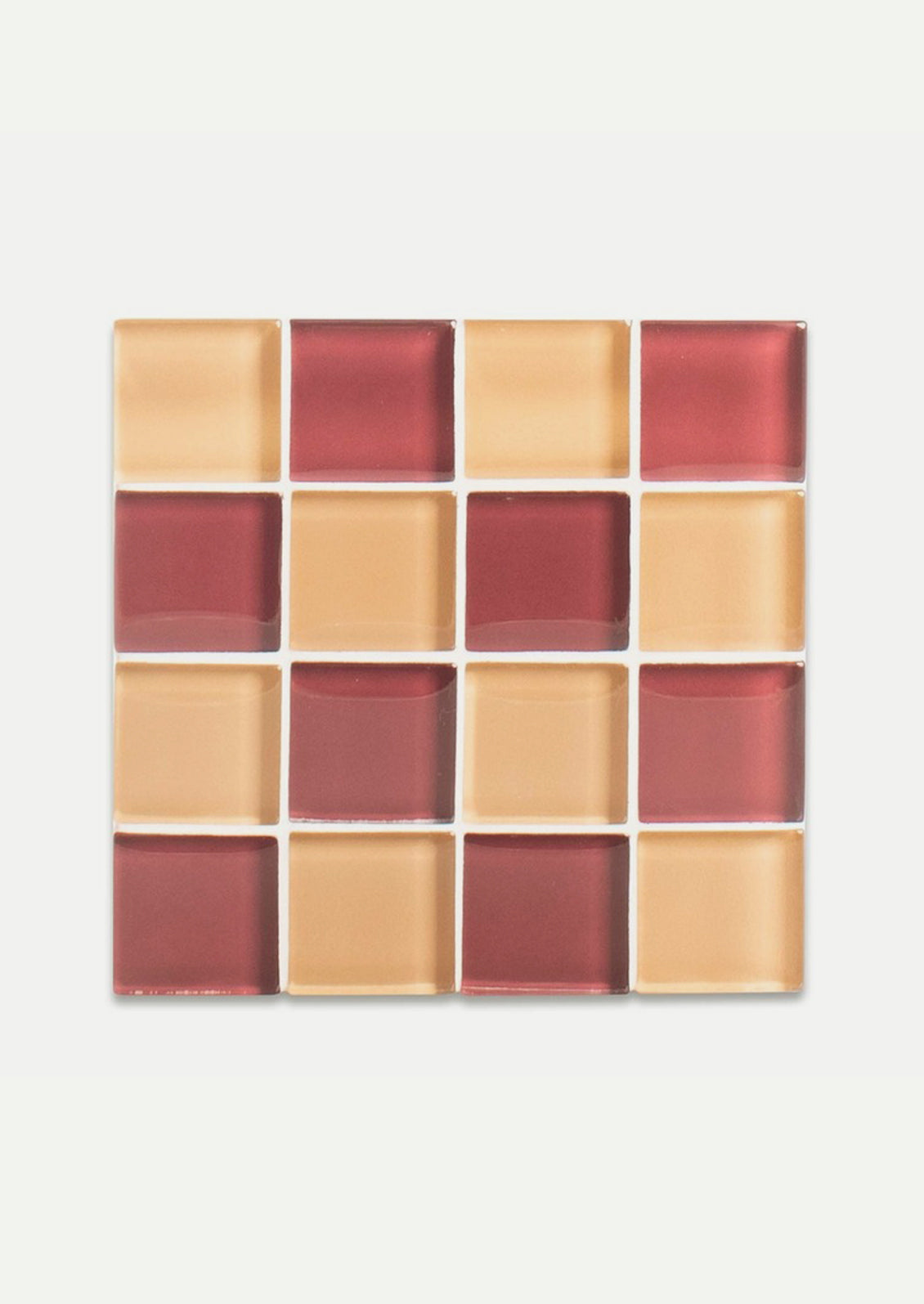 A glass tile coaster in two tone checker pattern in burgundy and peach.