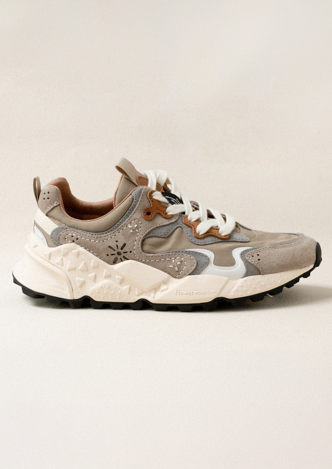 A sporty unisex sneaker in taupe, grey and brown.