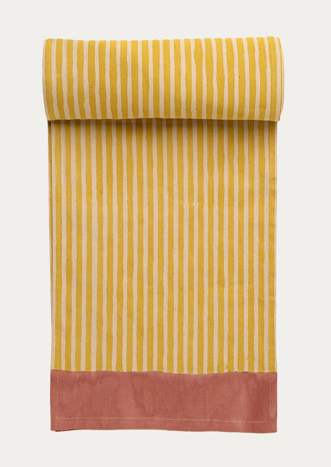 Striped fabric table runner with yellow and white stripes and a pink bottom section on a white background