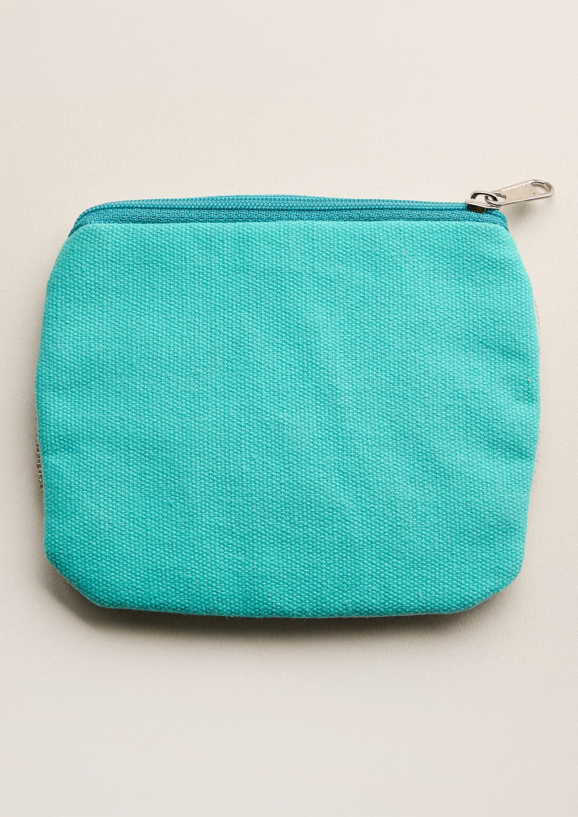 Turquoise zippered pouch on a beige background