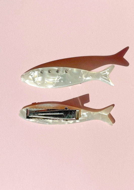 A pair of pearlescent sardine shaped hair clips.