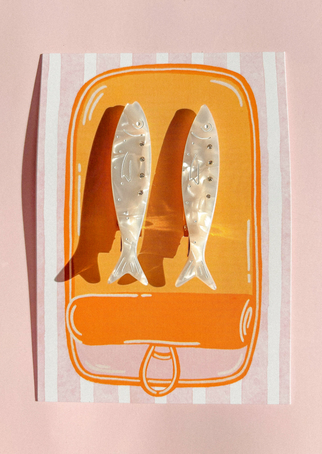 A pair of pearlescent sardine shaped hair clips.