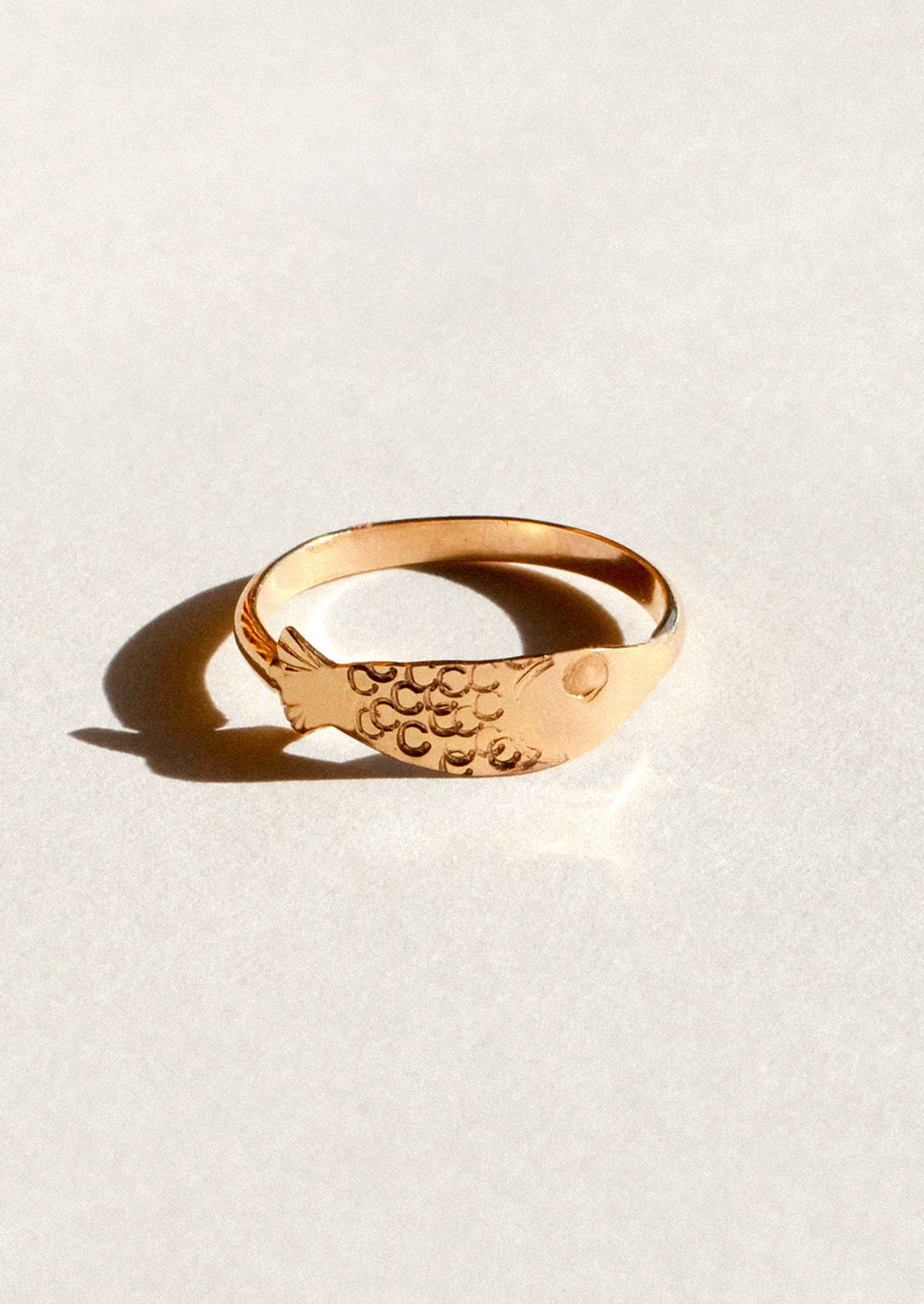 A gold ring in the shape of a sardine.