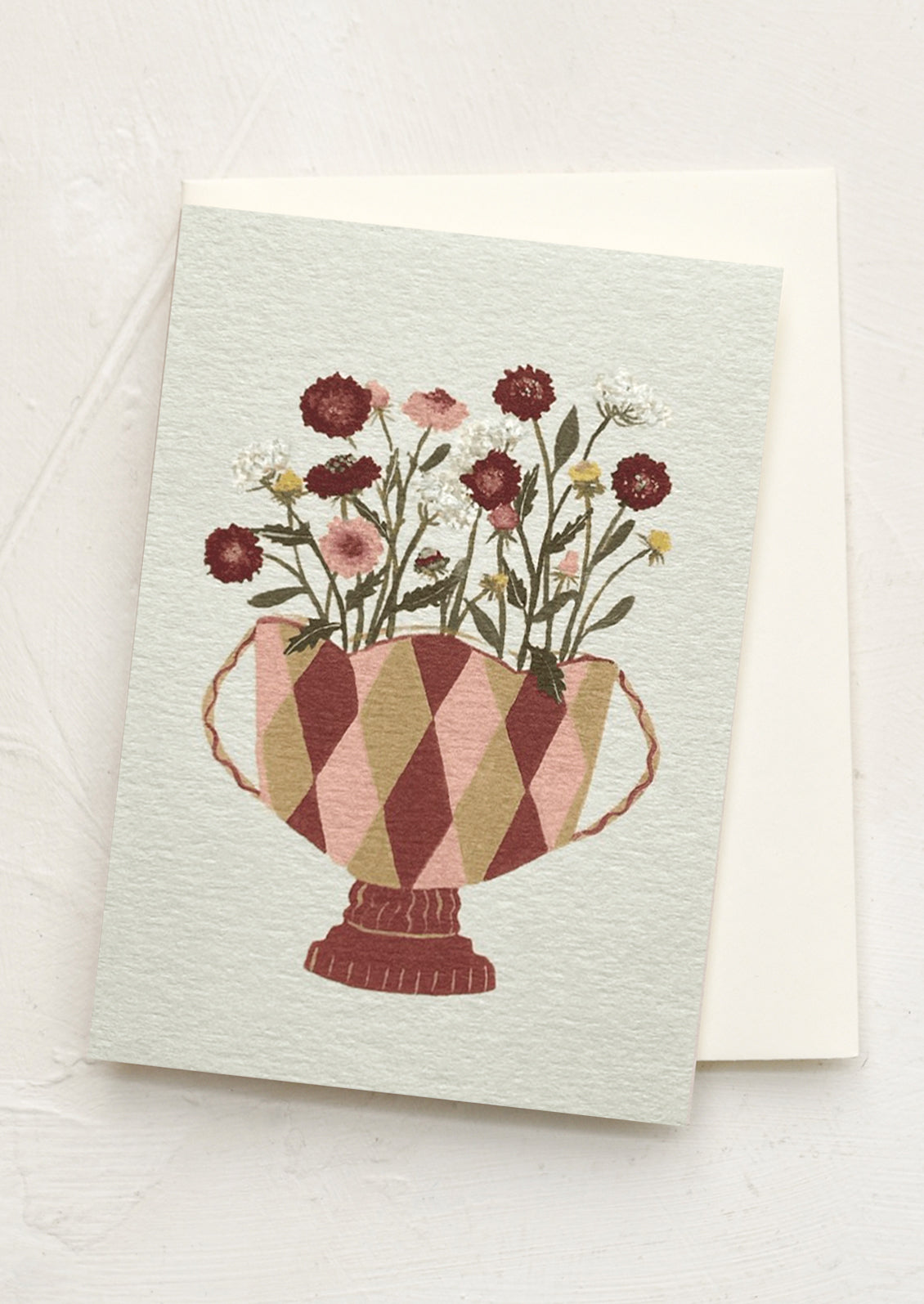 A mini greeting card in light grey with illustration of scabiosa flowers in pot.