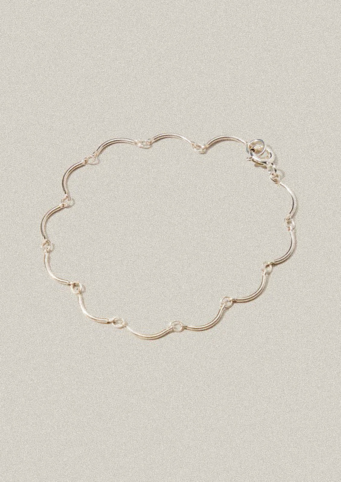 Silver bracelet on a light gray background