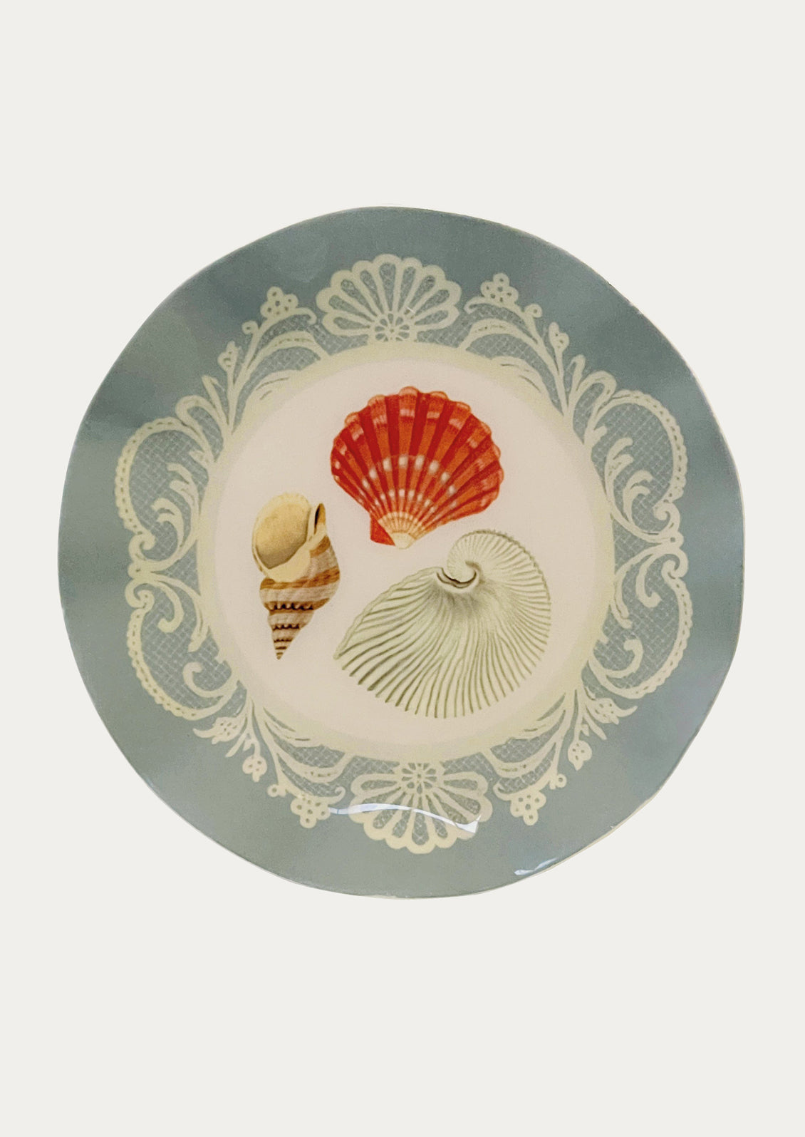 Decorative plate with shell designs on a light gray background