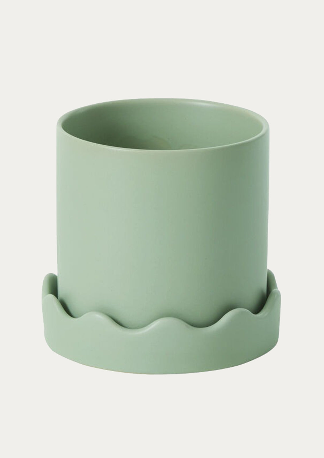 Green ceramic planter with wavy base on a white background