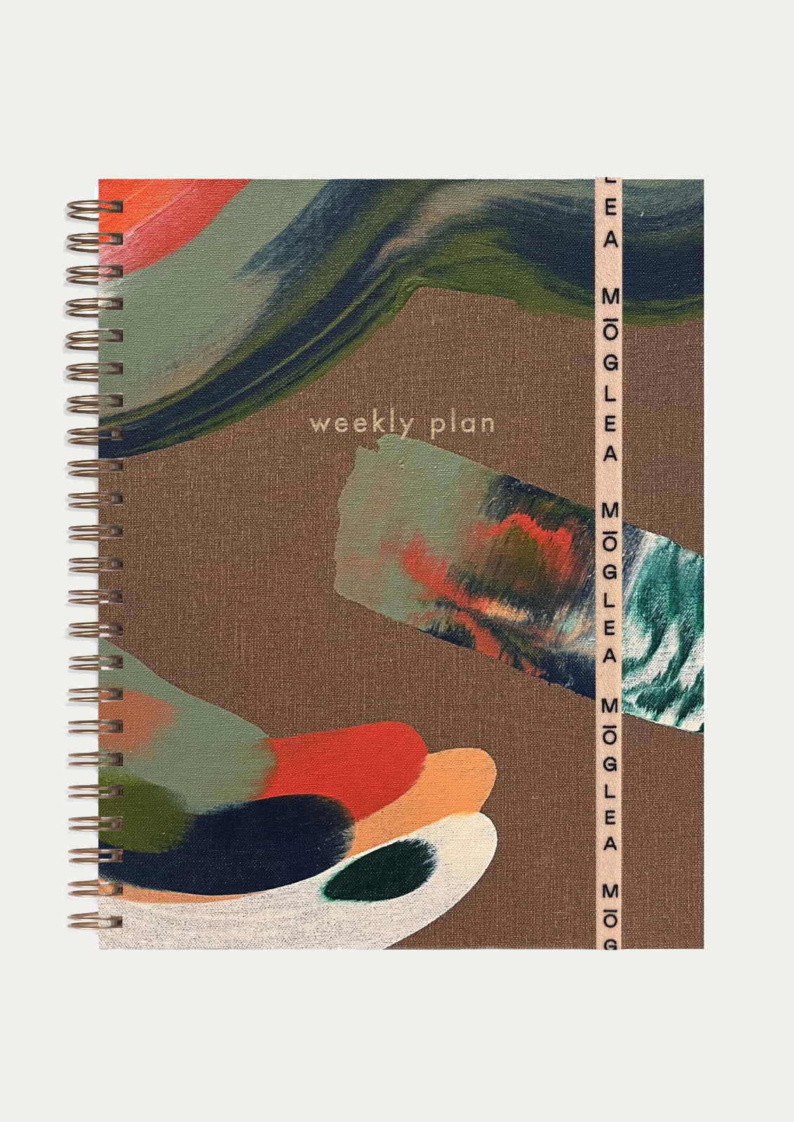 A hand painted wire bound planner reading "Weekly plan" on cover.