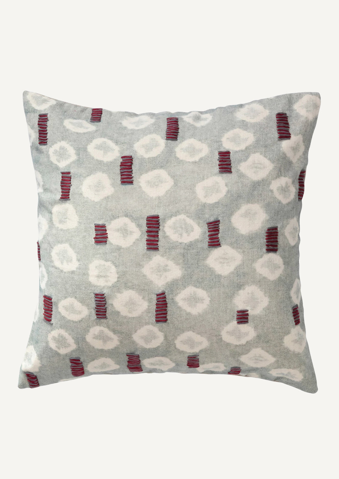 A square pillow in light blue batik tie dye pattern with red and grey embroidery detailing.