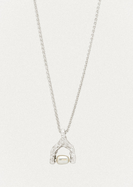 A sterling silver necklace with a wishbone-shaped charm that has a keshi pearl attached in the center.