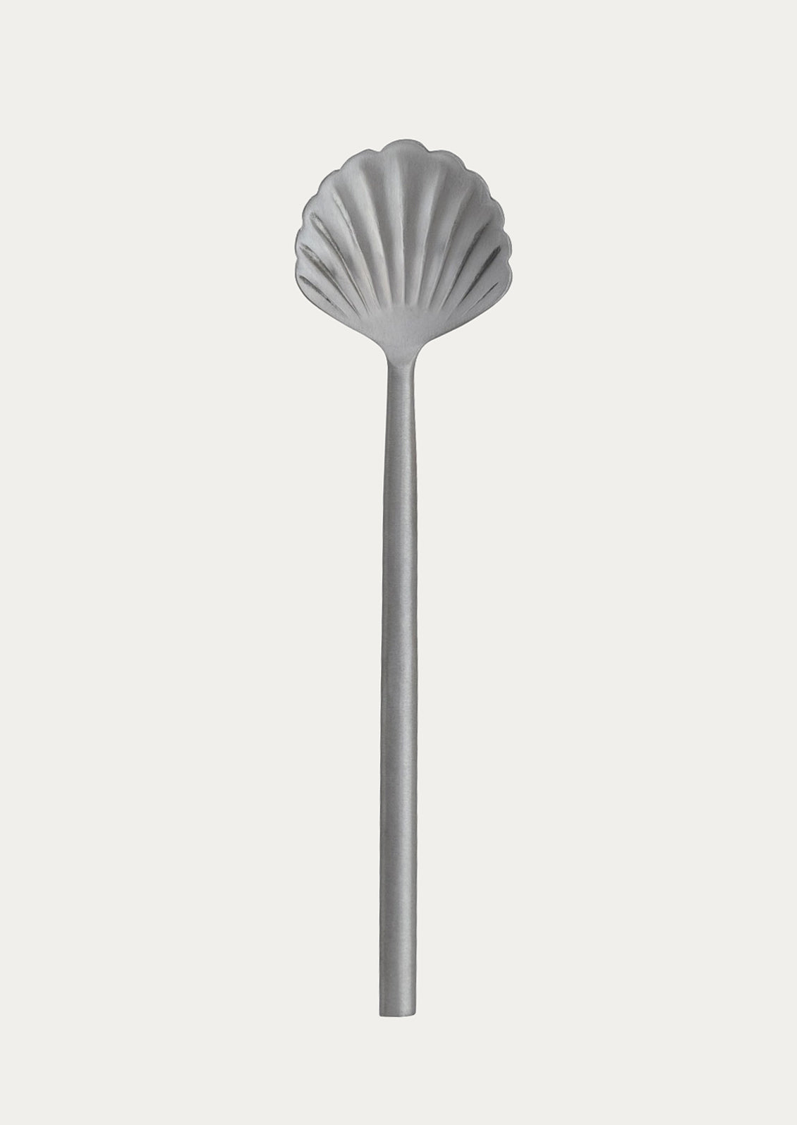 Silver shell-shaped spoon on a white background