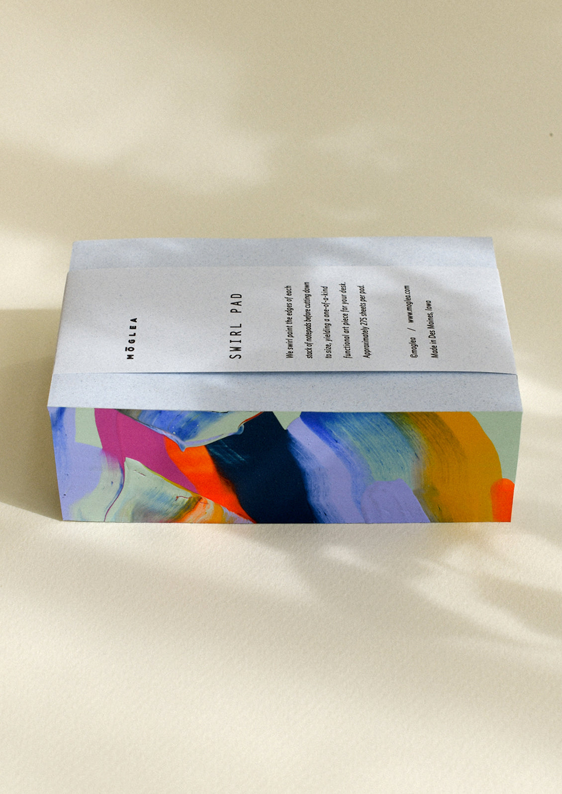 A chunky notepad with rainbow painted side.