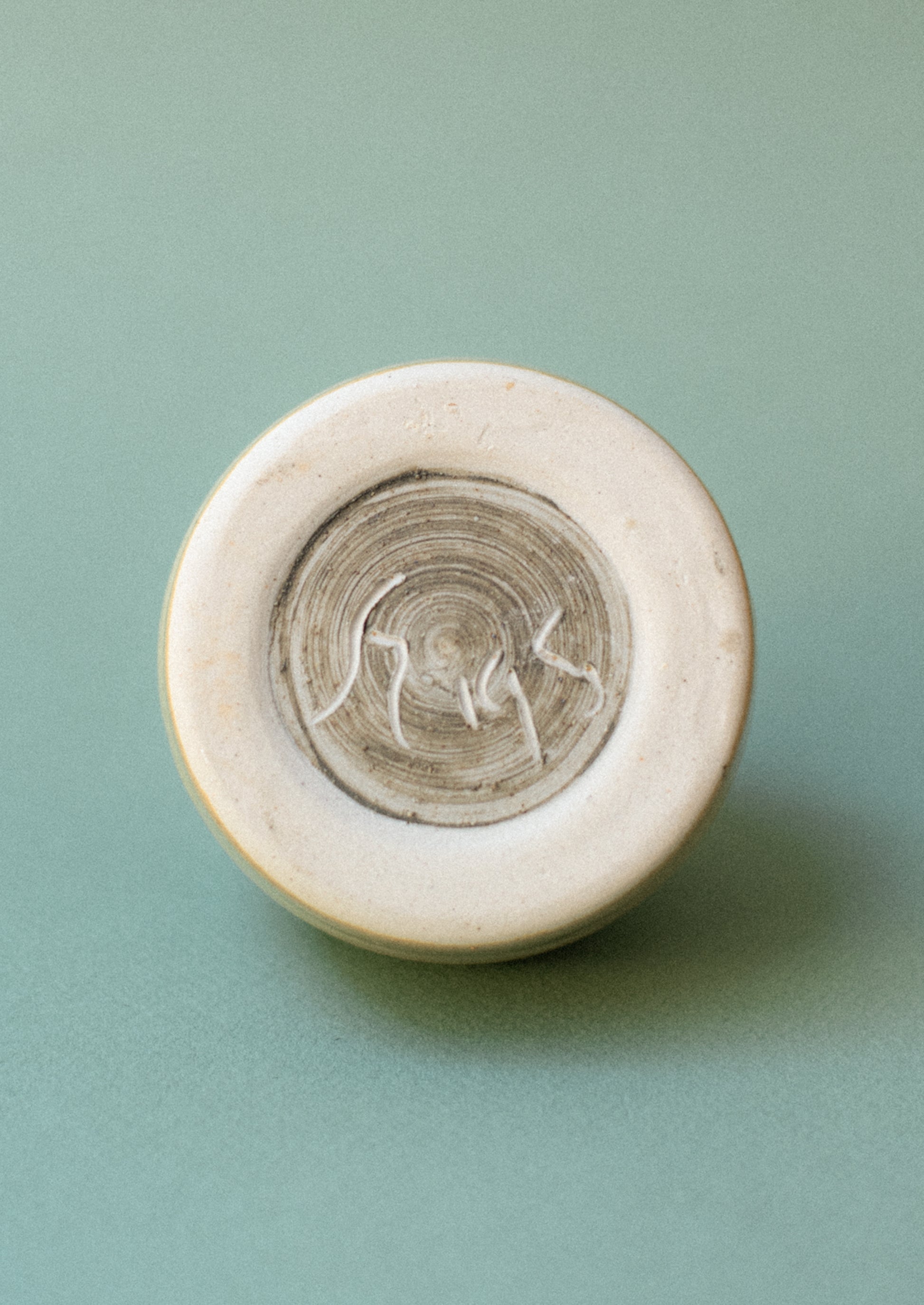 Maker's mark on bottom of ceramic jar.