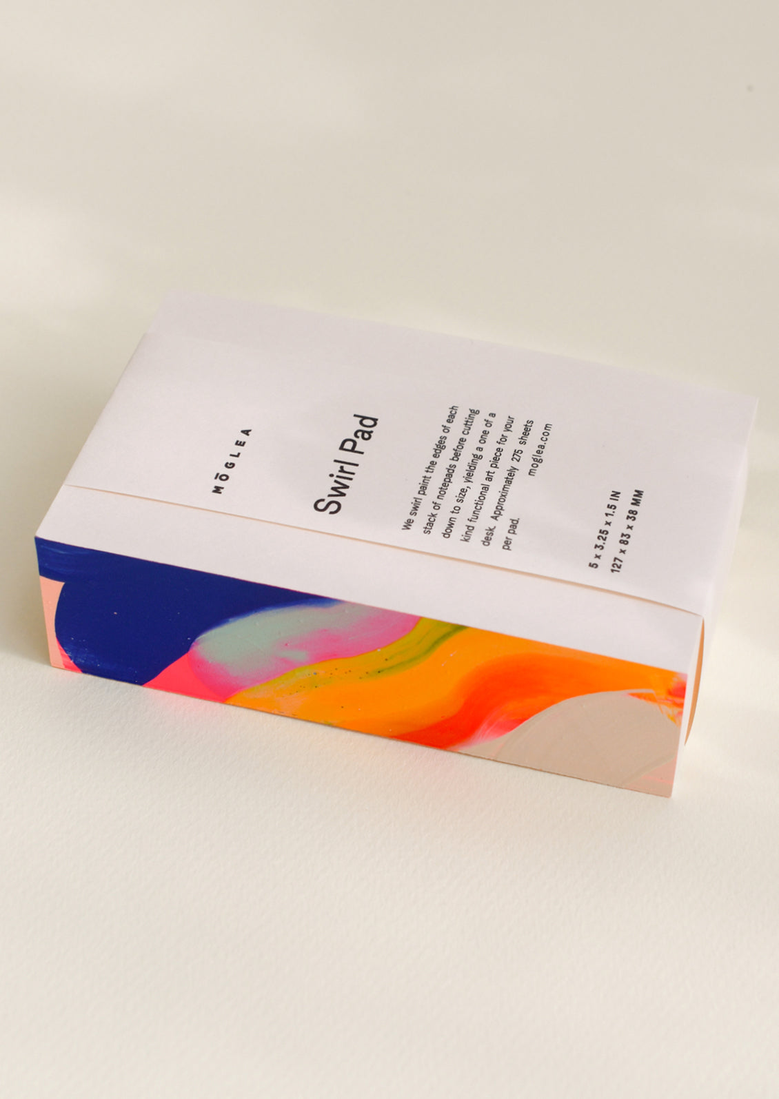 A chunky notepad with rainbow painted side.