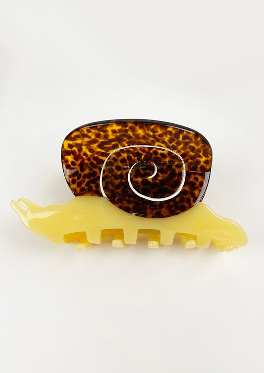 A snail shaped hair claw in brown and yellow.