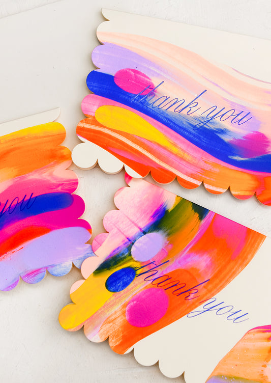 A card set with neon paintstrokes, scalloped edges, and blue cursive text reading "Thank you".
