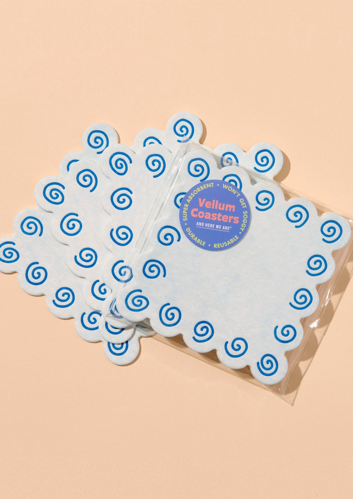 Set of blue coasters with blue spiral design on a beige background