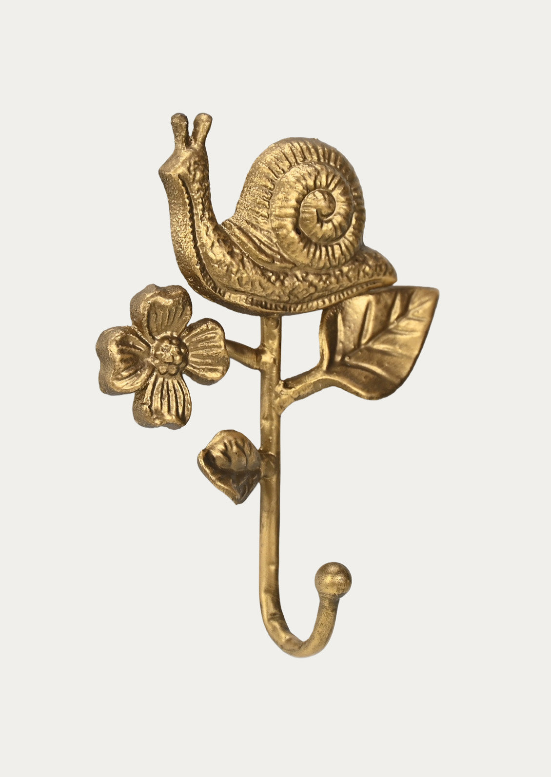 Side view of a handcrafted cast iron wall hook in the shape of a snail, flower, and leaves in a gold finish on a white background.