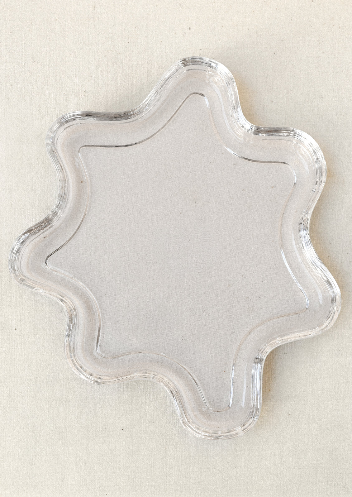 A clear glass tray in a squiggle shape.