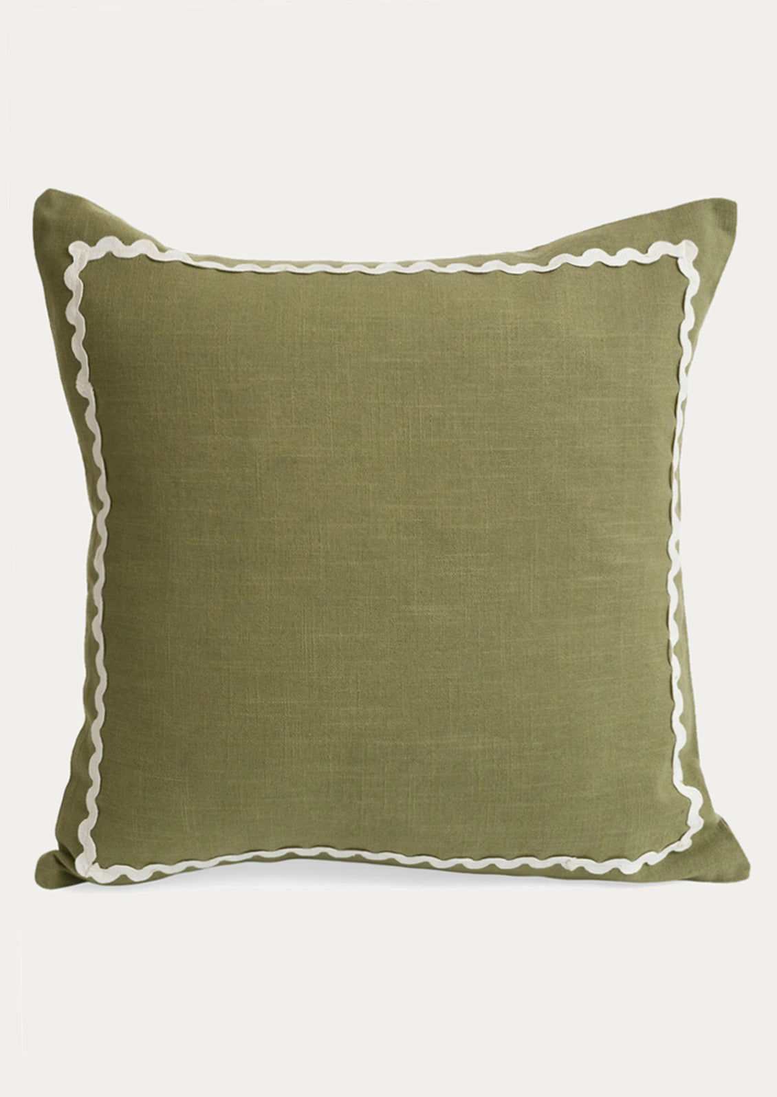 An olive green pillow with white ric rac border.