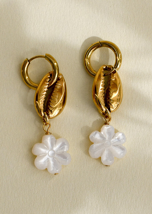 A pair of huggie hoop earrings with gold conch shell and mother of pearl flower charm.