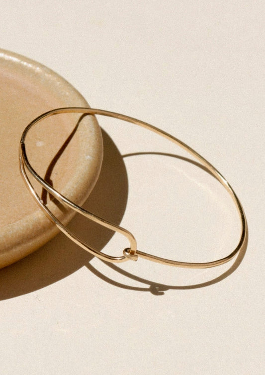 A minimal gold bracelet.