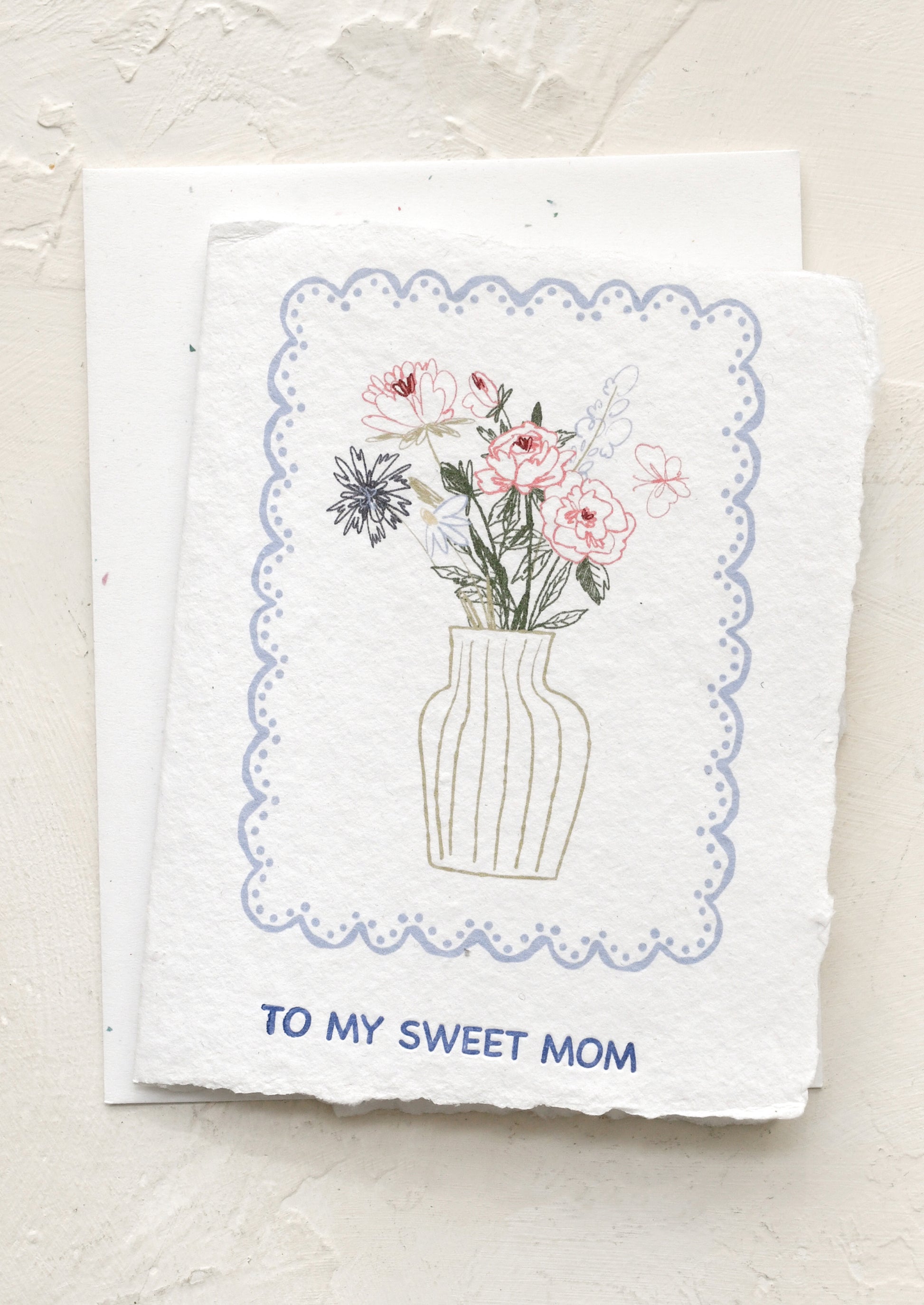 Greeting card with floral illustration and 'To my sweet mom' text on a textured surface