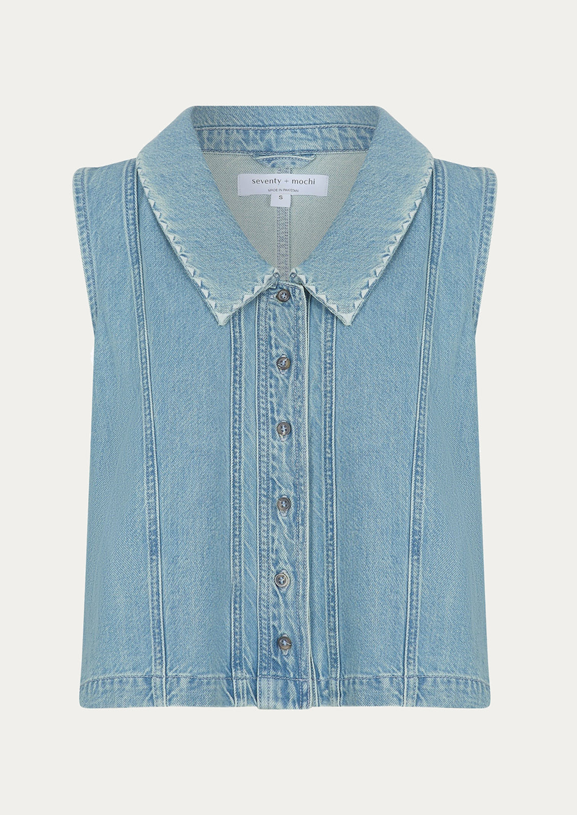A sleeveless button front top with pointed collar, in light wash denim.