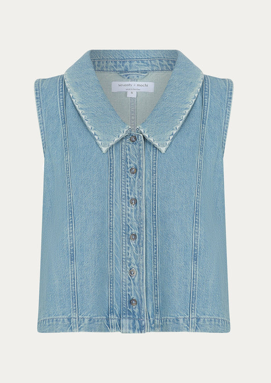 A sleeveless button front top with pointed collar, in light wash denim.
