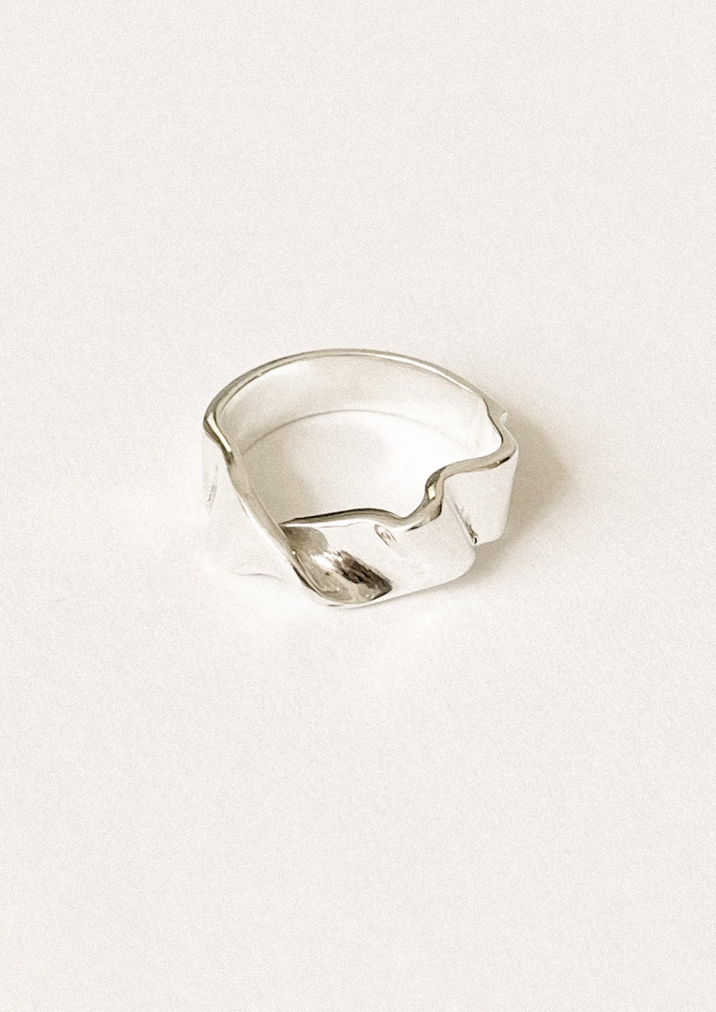 A sterling silver band ring in shape of fluid ribbon.