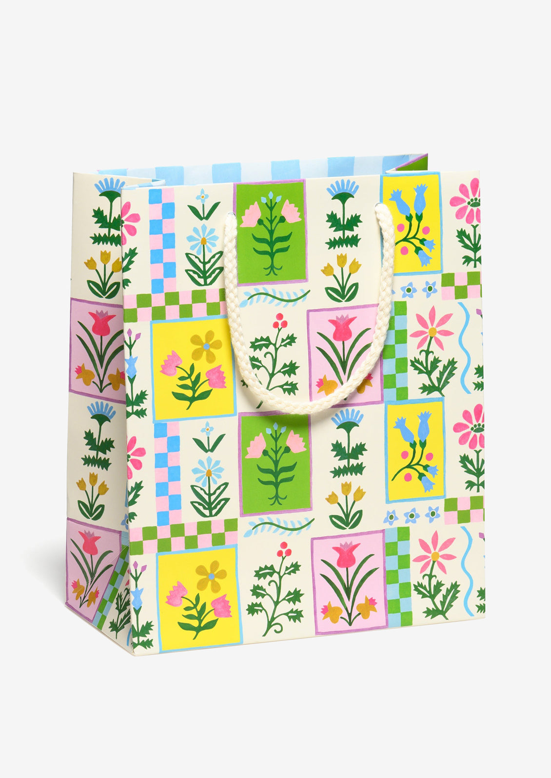 A printed gift bag with colorful retro floral tile print in yellow, pink, green and blue.