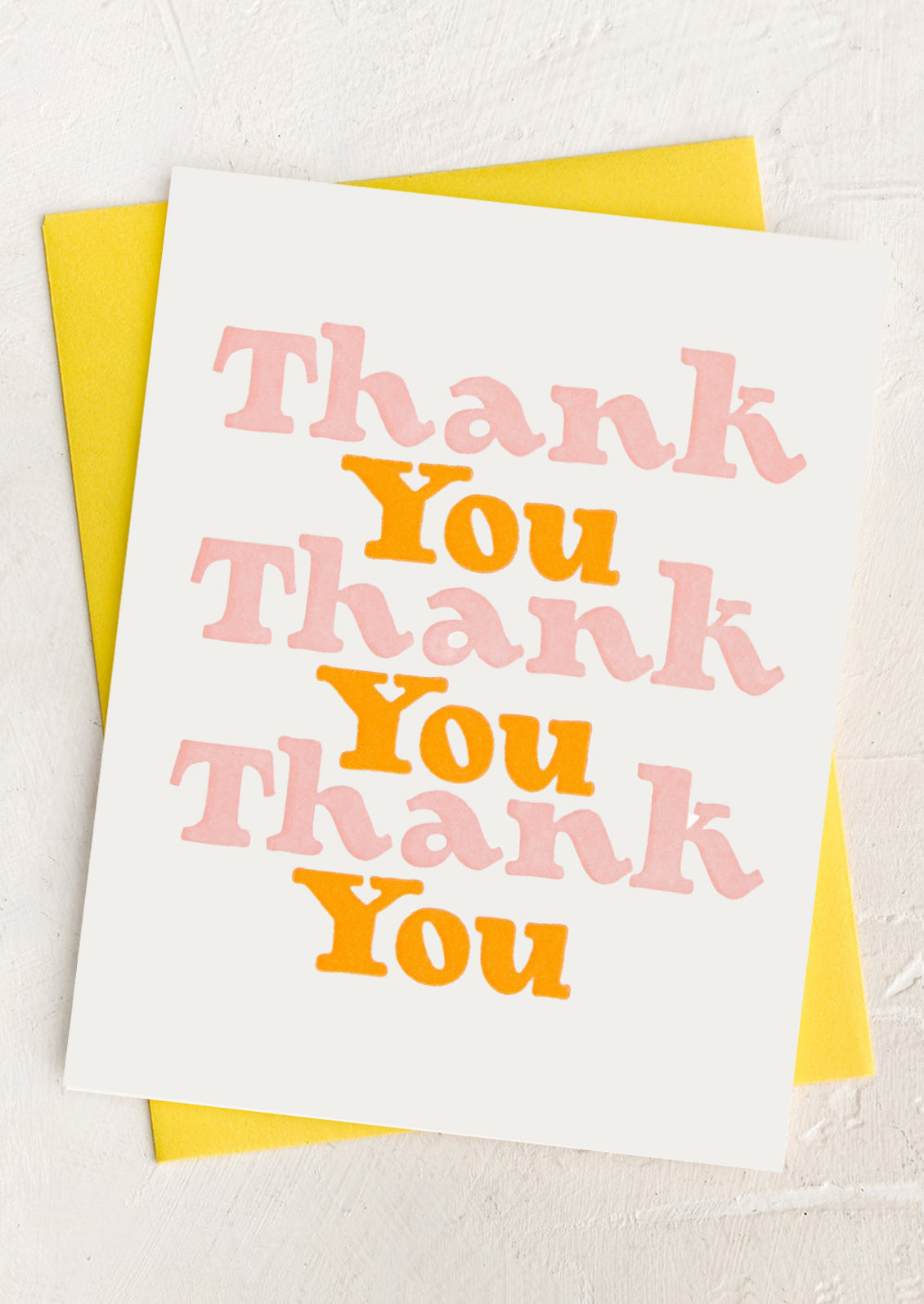Card with 'Thank You' text in pink and orange on a yellow envelope.