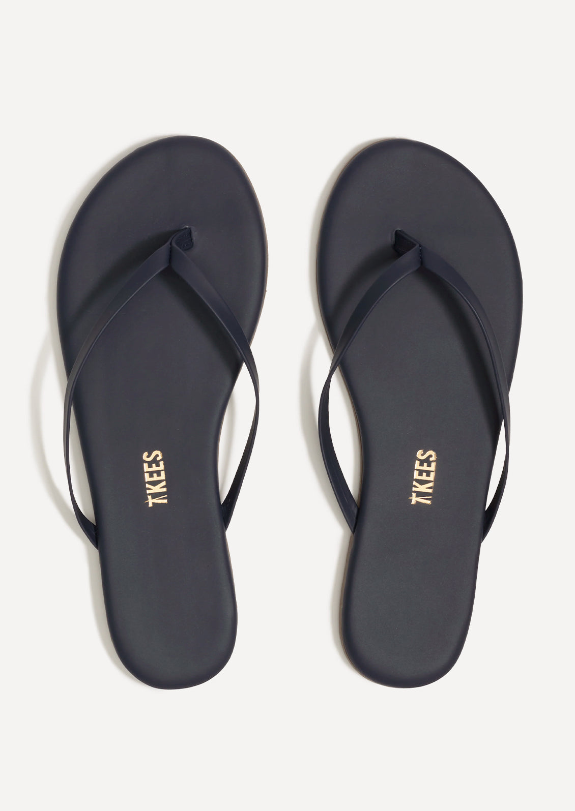 A pair of leather skinny strap TKEES sandals in dark navy.