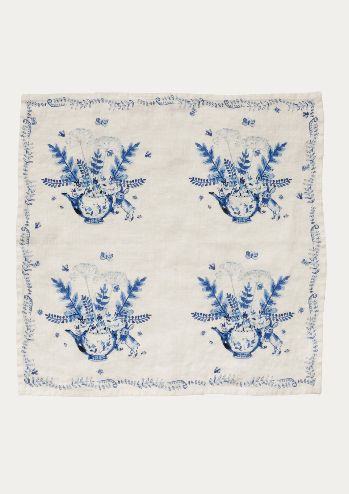 White napkin with blue floral and vase patterns on a white background