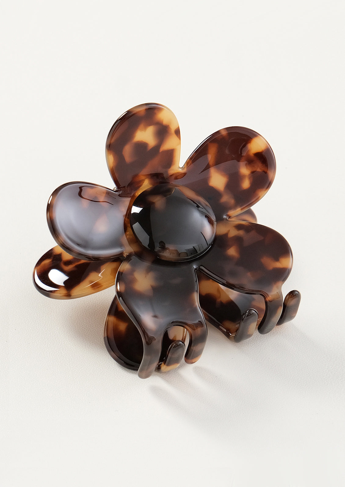Tortoiseshell flower-shaped hair clip on a white background