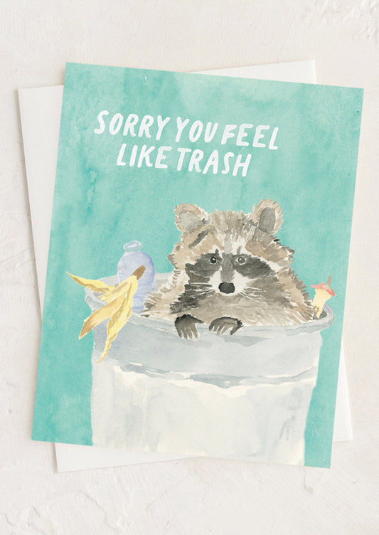Card with a raccoon illustration and text 'Sorry you feel like trash' on a light background