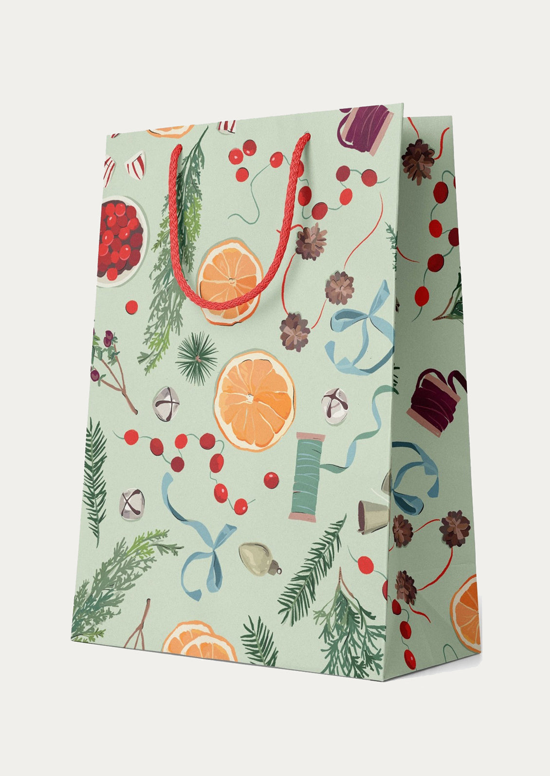 Gift bag with festive pattern featuring fruits, ribbons, and leaves on a light green background
