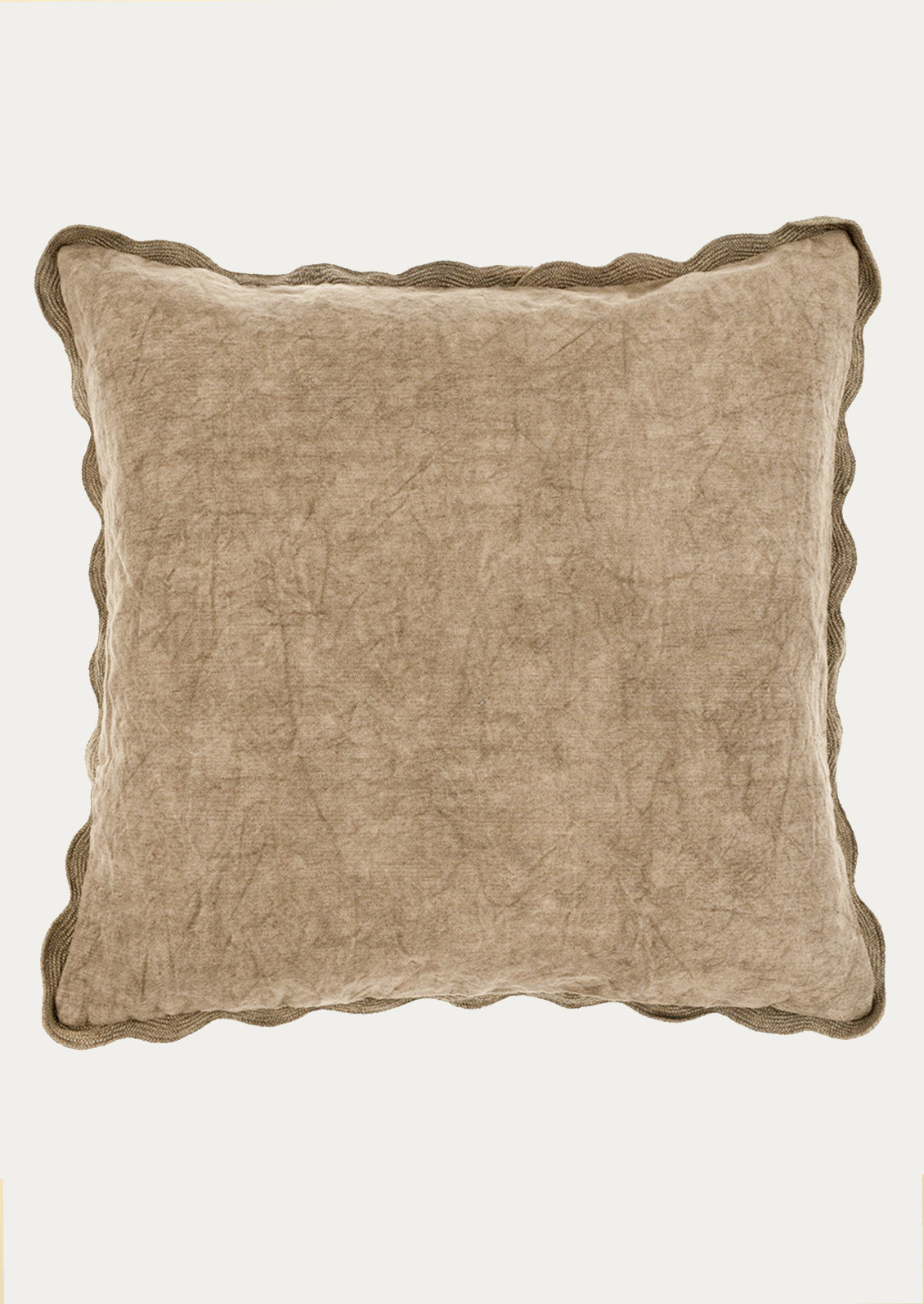 Beige pillow with scalloped edge on a white background