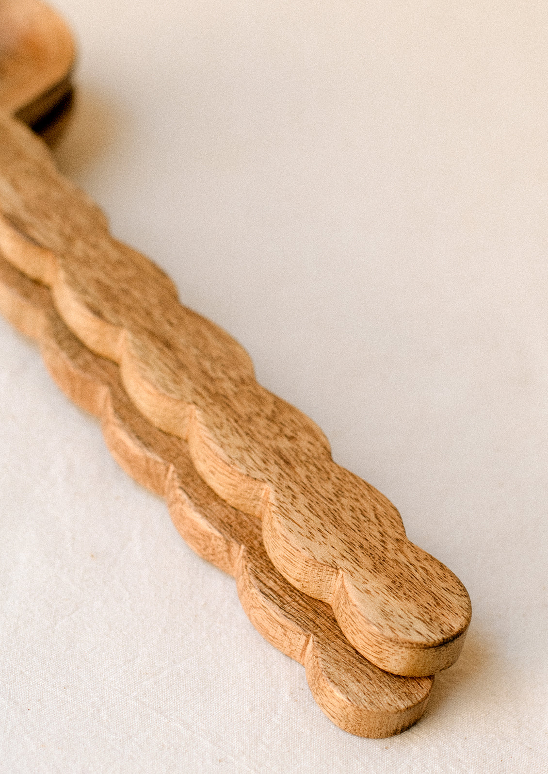 Mango wood salad serving set with wavy/scalloped handle.