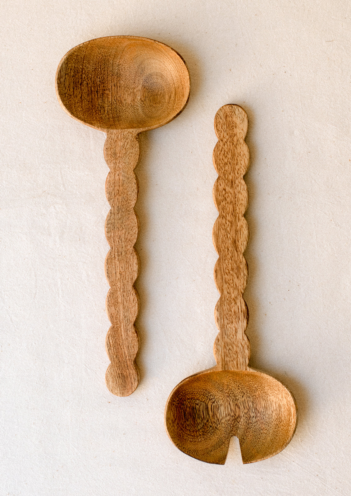 Mango wood salad serving set with wavy/scalloped handle.