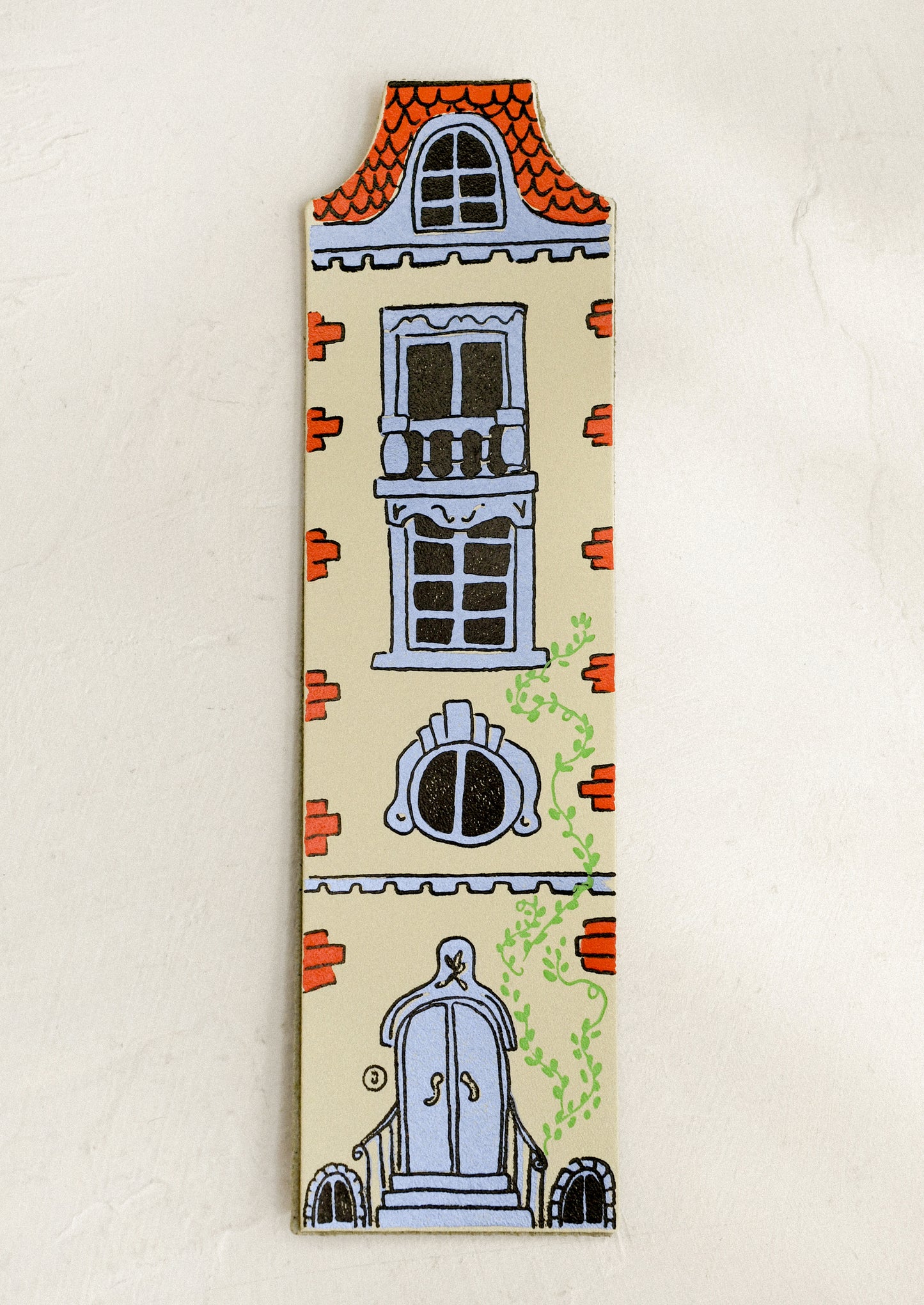 Decorative doll-house shaped bookmark with architectural illustrations on a beige background