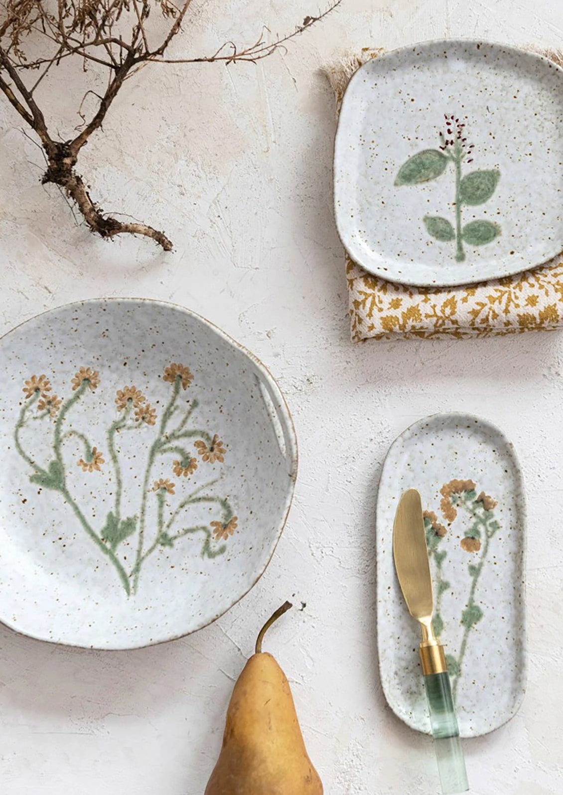 A ceramic serving bowl with cutout side handles and yellow painted flower at center.