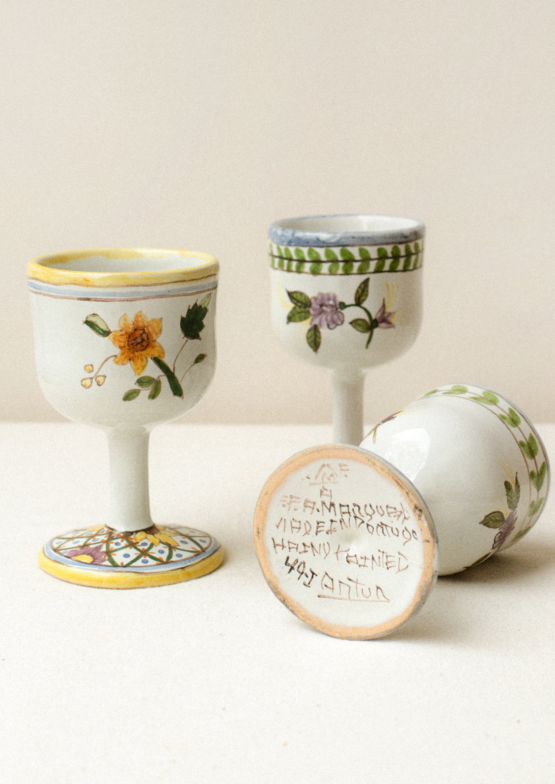 A set of four floral painted wine glasses.