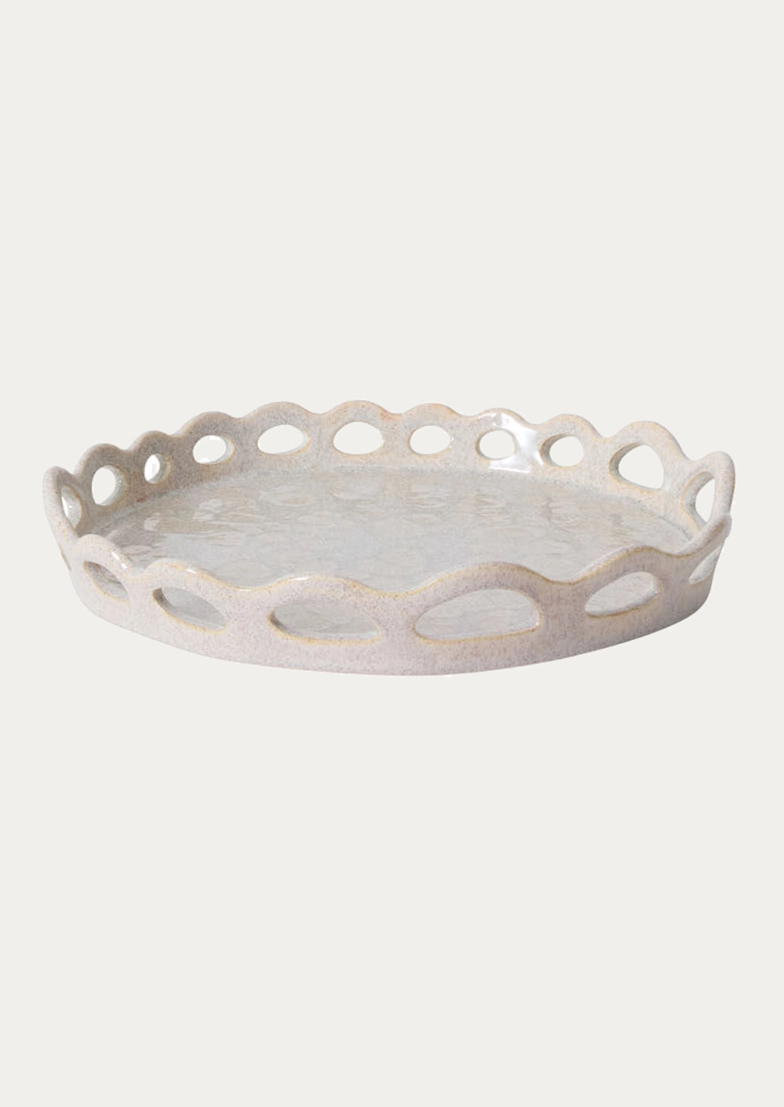 A round ceramic tray with a scalloped edge and cutout details, shown on a plain light gray background.