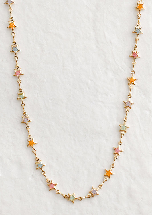A gold necklace with multicolor pastel star stations.