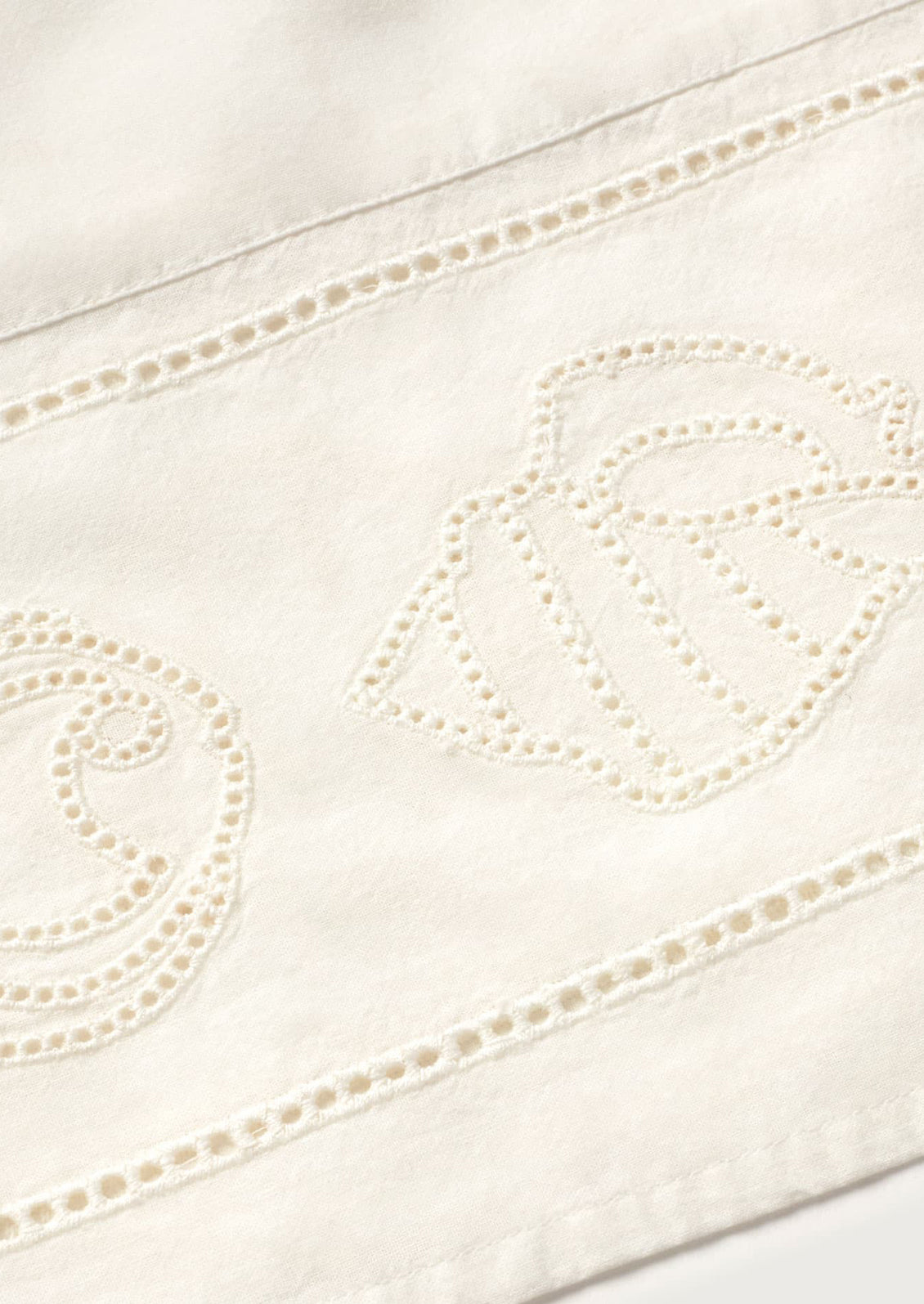 Close-up of a white fabric with decorative stitching on a white background
