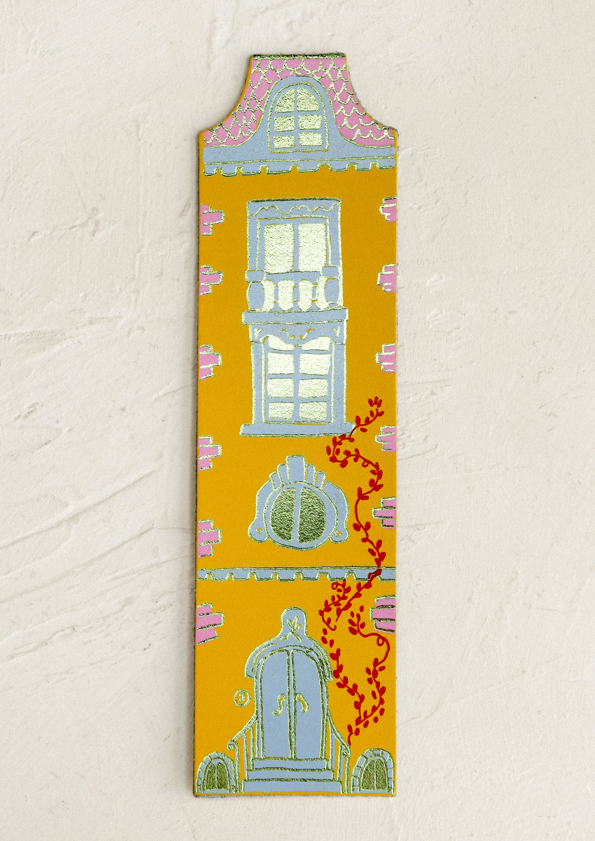Decorative doll-house shaped bookmark with architectural illustrations on a beige background